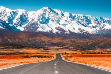 Wall Mural - Beautiful road in autumn mountains. Chuysky tract and view of North-Chuya mountain ridge in Altai, Siberia, Russia. Snow-covered mountain peaks and yellow autumn forest