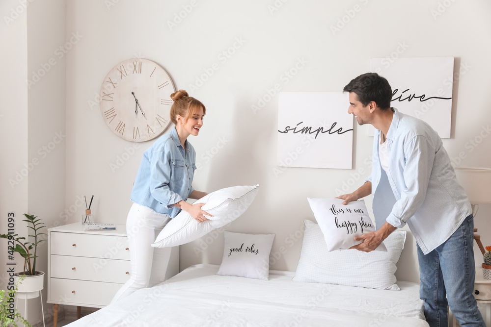 Young couple making their bed