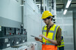 © visoot - Control Room Engineer,Power Plant Control Panel,Portrait of electrician engineer use tablet computer taking notes at control room in factory.