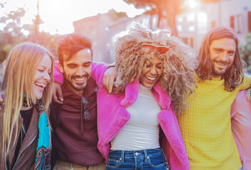 Group  of international friends walking at sunset in the park while having fun together