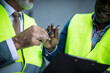 © liderina - Engineer signing  contractor. Two business men outside. Focus is on hands.