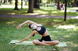 © teksomolika - Athletic young woman in a medical protective mask, doing yoga in the Park