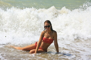 Wall Mural - Young woman on sand by sea wave