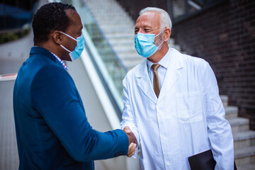 Two men, a doctor and  business man and an engineer talking on the street.