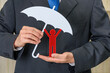 © William W. Potter - Personal or general data protection, privacy law concept : Businessman with umbrella protects a red doll, depicts protecting client from using of personally identifiable information e.g sensitive data