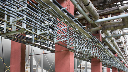 Cable route on steel supports. Rows of parallel power cables laid in route for power supply of petrochemical production facilities. Industrial background 16x9.