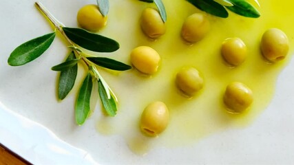 Wall Mural - Green olives and olive branch in olive oil in a ceramic gray cup.Natural farm fresh olive oil and olives