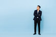 © Atstock Productions - Full length portrait of young handsome southeast Asian businessman with arms crossed looking up sideway to copy space on light blue studio background