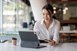 © amnaj - Asian  businesswoman beauty smiling holding credit card card shop online using a tablet at the office.