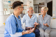© Zoran Zeremski - Male nurse talking to seniors patients while being in a home visit.