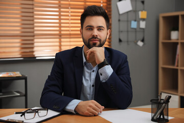 Poster - Portrait of young businessman at desk in office