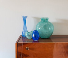 Mid-century Turquoise Blue Modern Artisan Glass Vase Collection On A Wooden Table With Plants Before The Window