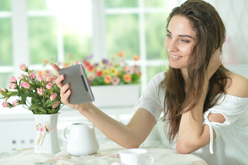 Portrait of  woman using tablet computer taking selfie