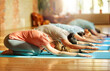 © Syda Productions - group of people doing yoga exercises at studio