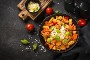 Wall Mural - Pasta chicken with vegetables on black.