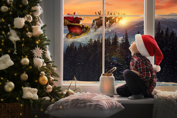 Sticker - Cute little child on window sill at home waiting for Santa Claus. Christmas celebration