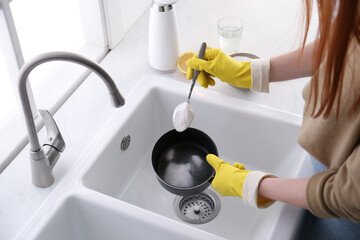 Wall Mural - Woman using baking soda to clean pot, closeup