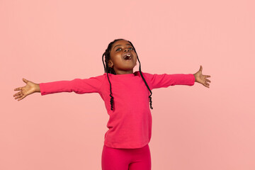 Handsome african little girl portrait isolated on pink studio background with copyspace