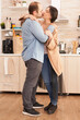 © DC Studio - Couple kissing in kitchen while dancing on romantic music. Wife and husband love, romance, tender moment, fun and happiness at home, togetherness music cheerful and smile