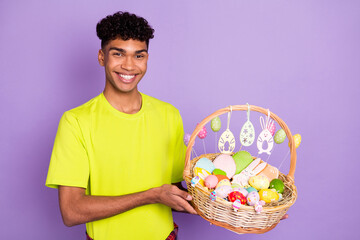 Sticker - Photo portrait of young curly guy keeping easter corb colorful eggs sweets celebrating holiday isolated on pastel purple color background