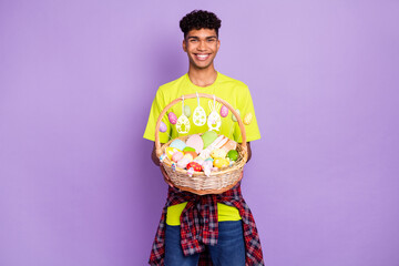 Sticker - Photo of young handsome attractive happy cheerful smiling afro man hold easter basket isolated on violet color background