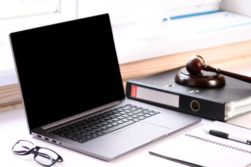 . Jurisprudence courses. On the table there is a computer and a folder with business papers. Online learning