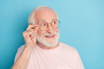 Poster - Photo of aged man pensioner happy positive smile hand touch glasses look empty space isolated over blue color background