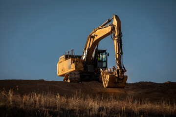 Wall Mural - Excavator on a steep hill at a construction site