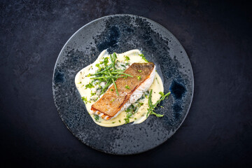 Wall Mural - Modern style traditional fried skrei cod fish filet with mashed potatoes and glasswort served as top view on ceramic design plate with copy space