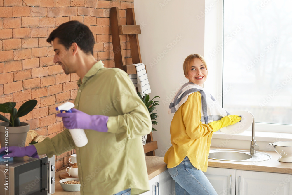 Young couple cleaning their kitchen