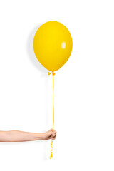 Hand hold yellow balloon. Party or present concept. Yellow Balloon and hand isolated on white background.