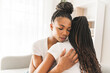 © Louis-Photo - Mother and daughter consoling on sofa at home