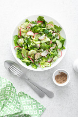 Canvas Print - Salad bowl of fresh vegetables with radish, cucumber, romaine lettuce, bell pepper and greens. Healthy food