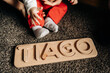 © Jake Jakab/ADDICTIVE STOCK - Cropped unrecognizable little baby playing on floor with wooden toy with Tiago name letters