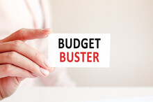 Budget Buster Written On A Paper Card In Woman Hand