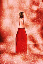 Fine Wine Rose Bottle Surrounded By Shiny Sparkling Lights And Placed On Red Background