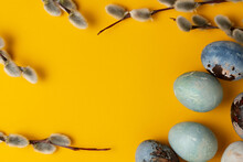 Beautiful Blue Easter Eggs With Willow Twigs On A Yellow Paper Background