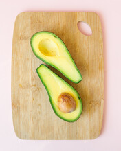 Half Ripe Avocado On Pink Background Or Wooden Chopping Board, Vegan Food Healthy And Healthy Food For The Whole Family