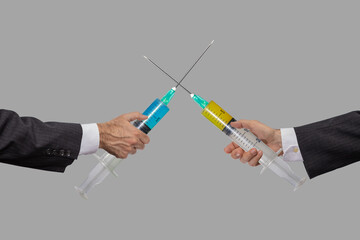 arms fighting with vaccine syringes on gray background