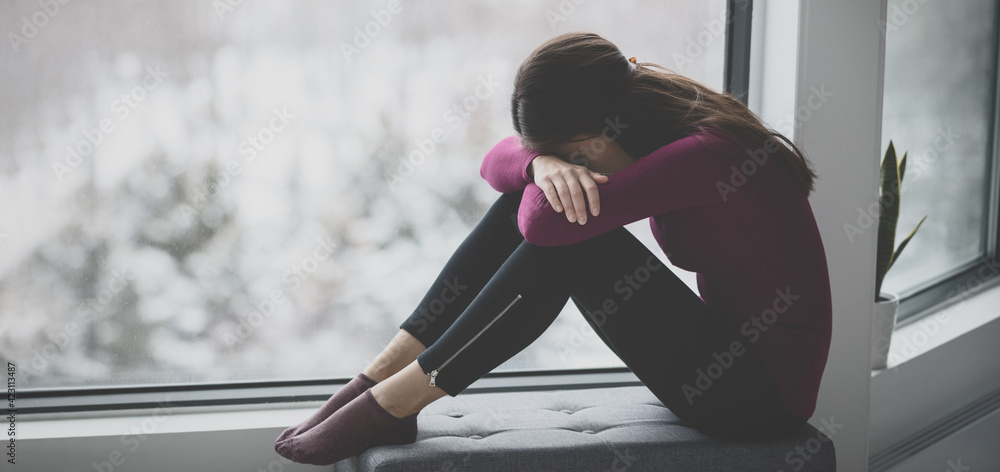 Sad crying young woman hiding face in sadness alone at home in isolation. Mental health problem social anxiety panic attack ptsd effects from the coronavirus pandemic. - obrazy, fototapety, plakaty 