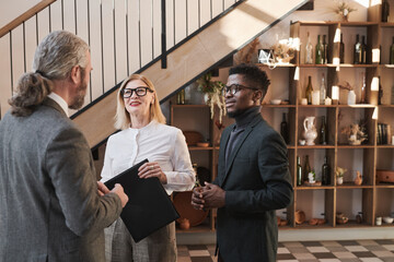 Wall Mural - Business people listening to their business leader while standing at modern office