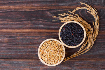 Wall Mural - Various types of rice ; black rice and paddy in wooden bowl isolated on wood table 