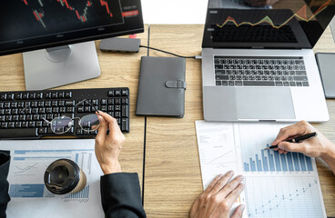 Wall Mural - Business team two colleagues working with computer, discussing and analysis graph stock market trading with stock chart data, financial and investment concept