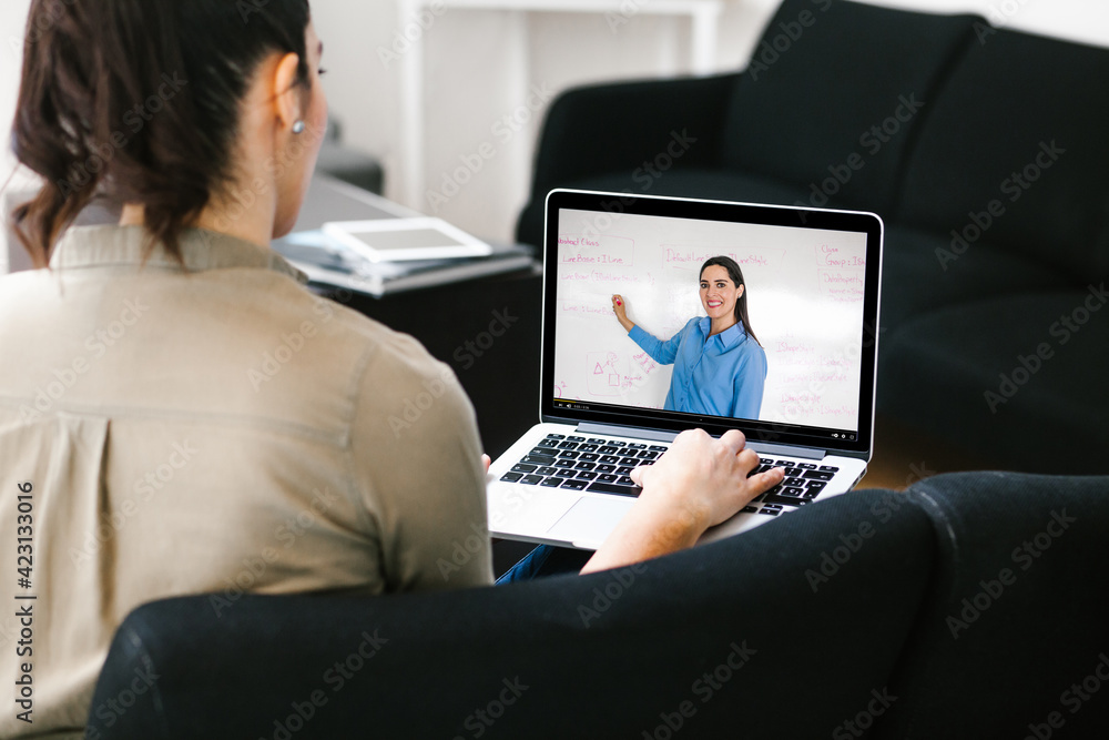 latin woman student watching lesson online and studying from home in Mexico city - obrazy, fototapety, plakaty 