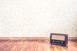 © terovesalainen - Retro vintage radio background with old wall paper texture pattern. Nostalgia music backdrop and wallpaper. 50s style stereo receiver and speaker on wooden floor. Rustic propaganda news show banner.