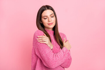 Poster - Portrait of brunette optimistic girl hug herself wear pink sweater isolated on crimson color background