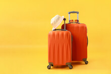 Two Suitcases Of Travel Bags, Straw Hat And Sunglasses On Yellow Background With Copy Space. Concept Of Summer Time, Vacation, Tourism.