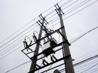 Wall Mural - Close up of power poles and towers in the background of blue sky