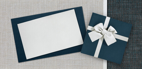 gift card and gift box with ribbon and bow isolated on elegant blue and grey fabrics background, top