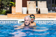 © Victor - Grandpa and grandson playing on a swimming pool at summer
